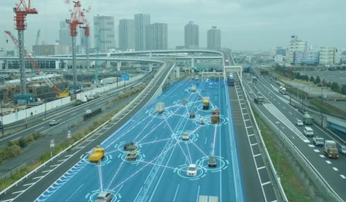 A highway scene overlaid with a digital network, showing cars connected by lines and circles, representing V2V (vehicle-to-vehicle) communication and smart traffic systems.