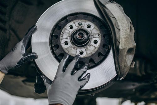 A mechanic installing or adjusting a brake rotor on a vehicle.